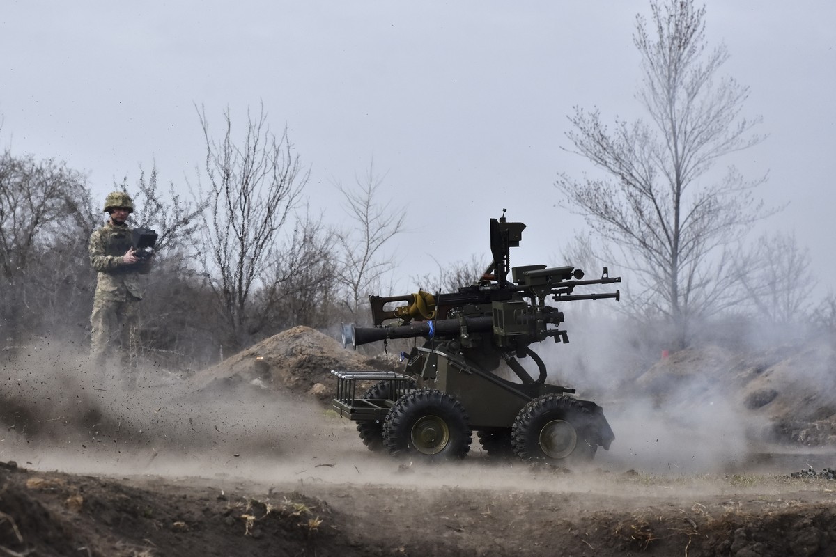 epa11962329 A handout photo made available by Ukraine's 65th Mechanized Brigade Press Service shows Ukrainian servicemen testing an unmanned ground vehicle (UGV) at a military training ground in  ...