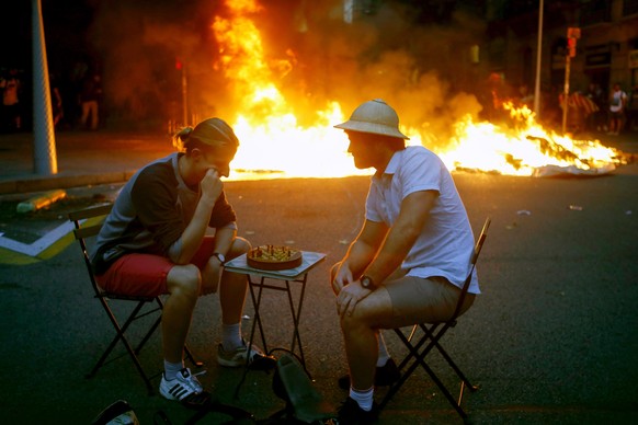 epa07931086 Two men pretend to play chess during clashes with police as thousands of people take part in one of the so-called &#039;Marches for Freedom&#039; along Pelayo street in Barcelona, Spain, 1 ...