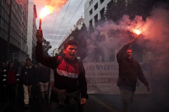 University students hold flares and chant slogans as they participate with striking teachers in a protest against planed education reforms in central Athens, on Friday, April 12, 2019.(AP Photo/Petros ...