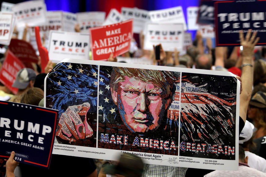 epa05584165 Supporters of the US presidential candidate Donald Trump, hold banners during the Trump’s campaign stop at the South Florida Fair Expo Center in West Palm Beach, Florida, USA, 13 October 2 ...