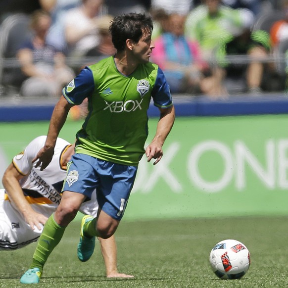 Seattle Sounders midfielder Nicolas Lodeiro, right, looks to pass as Los Angeles Galaxy midfielder Jeff Larentowicz goes down during the first half of an MLS soccer match, Sunday, July 31, 2016, in Se ...