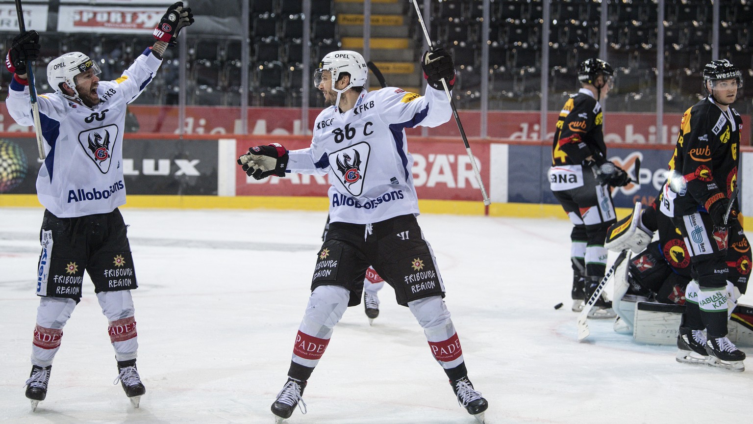 Gotterons Chris DiDomenico, links, und Julien Sprunger, rechts, feiern gegen Berns Ramon Untersander den Treffer zum 1-0 im Eishockey Meisterschaftsspiel der National League zwischen dem SC Bern und d ...