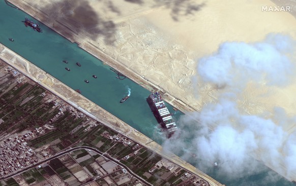 epa09105218 A handout satellite image made available by MAXAR Technologies shows , the Ever Given container ship after it has been moved away from the eastern bank of the canal and tugboats trying to  ...