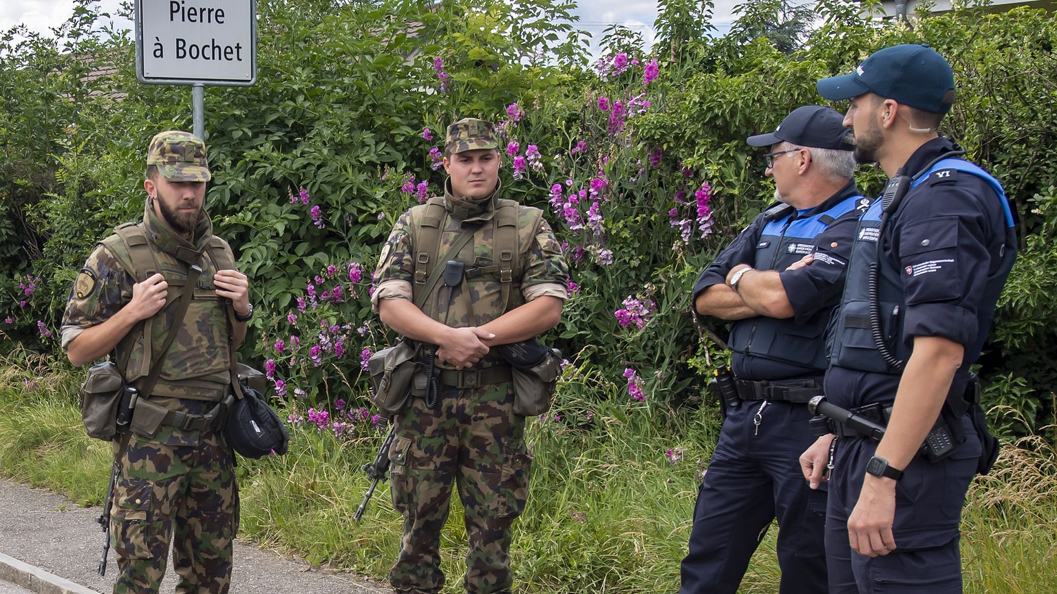 Swiss border guards and soldiers await the concrete blocks that closed customs access, in Thonex near Geneva, Switzerland, on Sunday, June 14, 2020. Concrete blocks closed the road at the Swiss-French ...