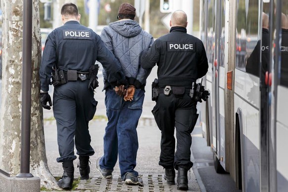 Genf ist am strengsten: Polizisten führen einen Ausländer ab..