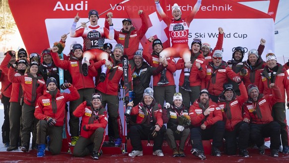 Second placed Franjo von Allmen of Switzerland, top left, and winner Marco Odermatt of Switzerland, top right, celebrate with their team members on the podium after the men&#039;s Downhill race at the ...