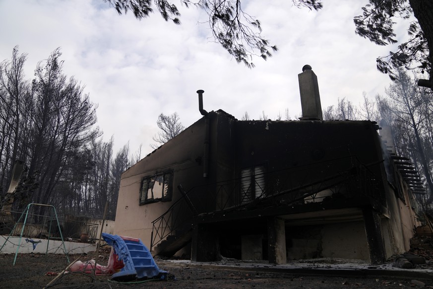 A burnt house after a wildfire in Drosopigi village, about 28 kilometres (27 miles) north of Athens, Greece, Friday, Aug. 6, 2021. Thousands of residents of the Greek capital have fled to safety from ...