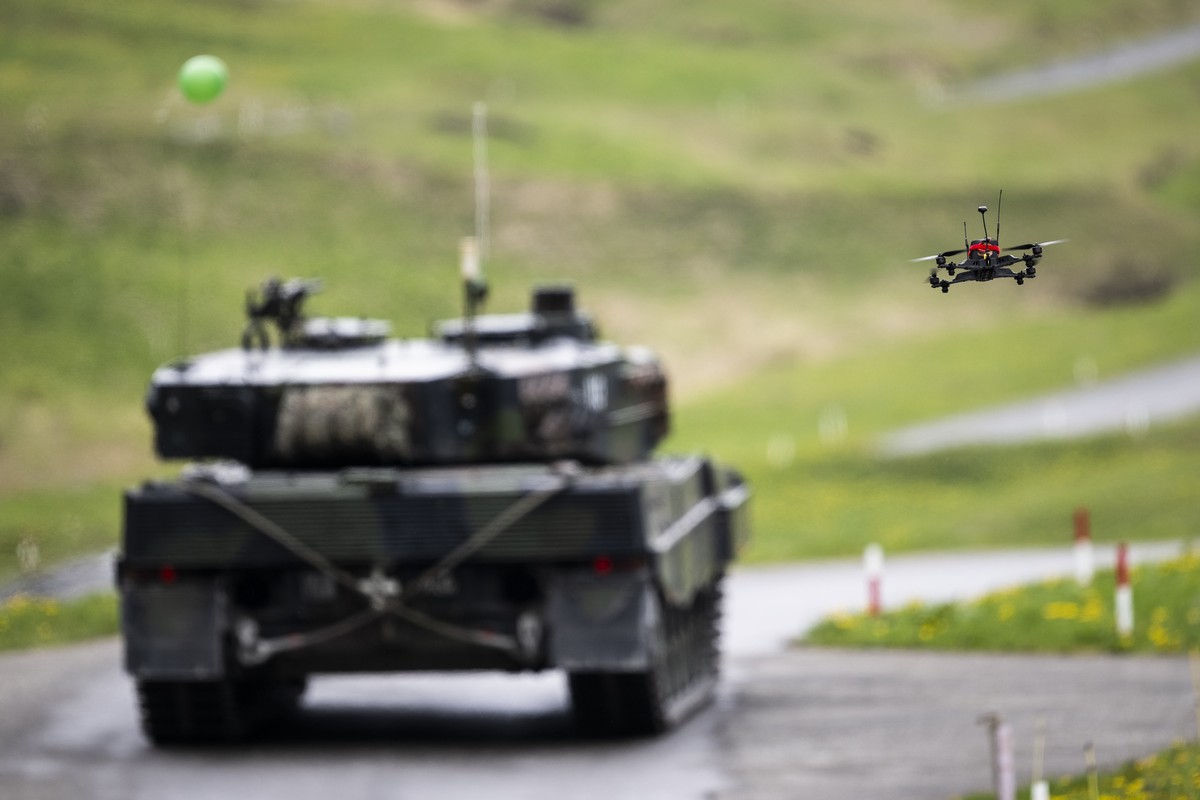 epa12971259 An attack drone flies toward a Leopard 2 tank marked with a balloon target during a Swiss Army media demonstration on the integration of drones into combat units at the Wichlen shooting ra ...