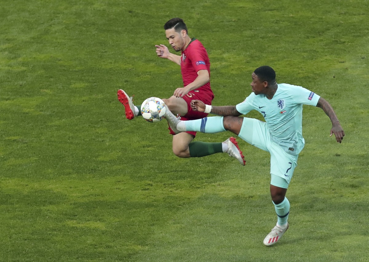 Portugal's Raphael Guerreiro, left, duels for the ball with Netherlands' Steven Bergwijn during the UEFA Nations League final soccer match between Portugal and Netherlands at the Dragao stad ...