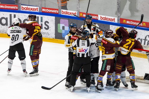 Players from Geneve-Servette and Lausanne (white) argue, during the third leg of the National League quarterfinal playoff game of the Swiss Championship between Geneve-Servette HC, GSHC, and Lausanne  ...
