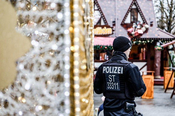 KEYPIX - epa12537534 A police officer patrols the Christmas Market in Magdeburg, Germany, 20 November 2025. The market opened under enhanced protective measures nearly a year after a man drove a car t ...