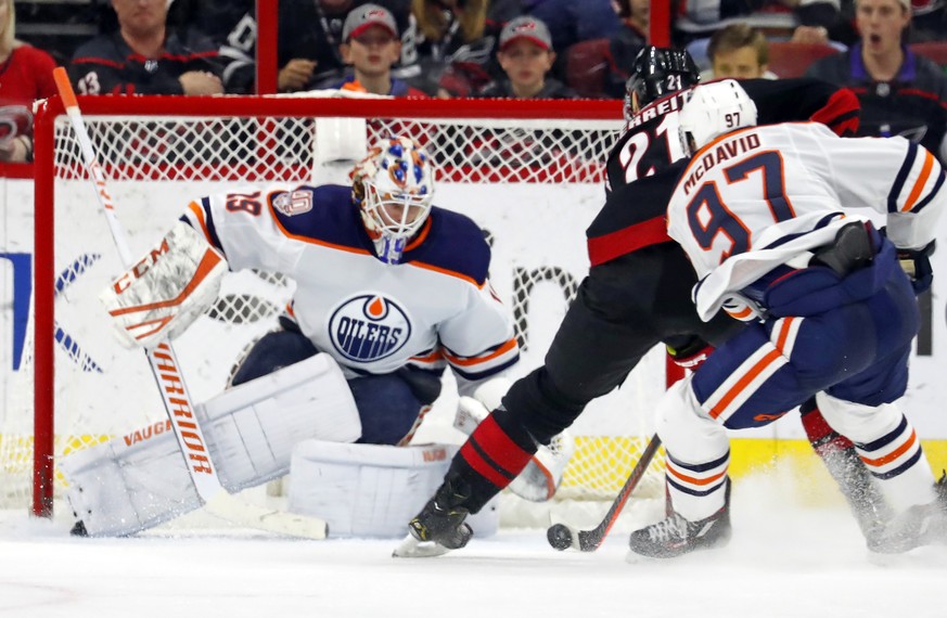 Carolina Hurricanes&#039; Nino Niederreiter (21) makes a move on Edmonton Oilers goaltender Mikko Koskinen (19) with Connor McDavid (97) giving chase during the third period of an NHL hockey game Frid ...