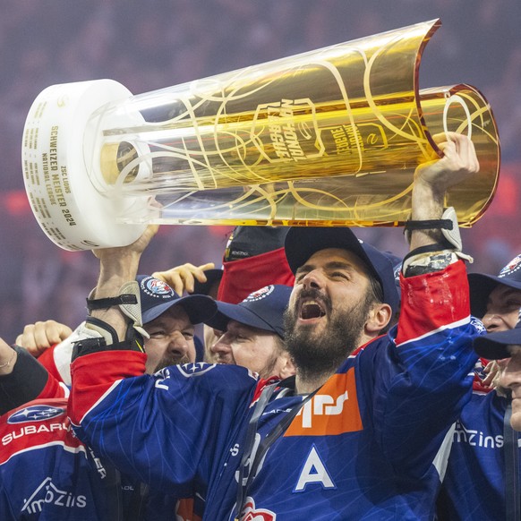 Die Spieler des ZSC mit Denis Hollenstein, rechts, feiern den Schweizermeister Titel nach dem Eishockey Playoff Final, Spiel 7 der National League zwischen den ZSC Lions und dem Lausanne HC am Diensta ...