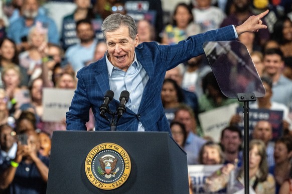 epa11443765 North Carolina Governor Roy Cooper introduces US President Joe Biden and First Lady Dr. Jill Biden during a campaign event at the Jim Graham Building at the North Carolina State Fairground ...
