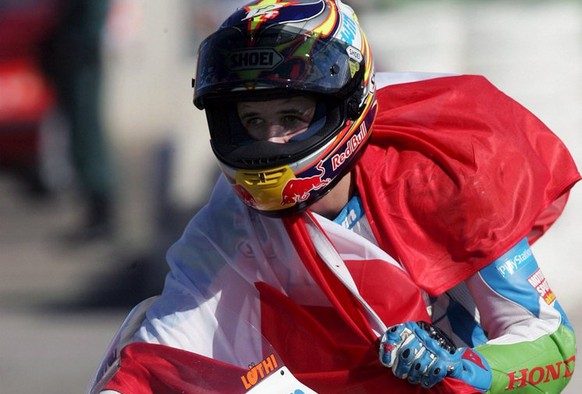 Swiss rider Thomas Luethi of Honda holds a Swiss flag after becoming the new 125cc. world champion following today&#039;s race at &#039;Ricardo Tormo&#039; circuit in Cheste, Valencia, Sunday 06 Novem ...