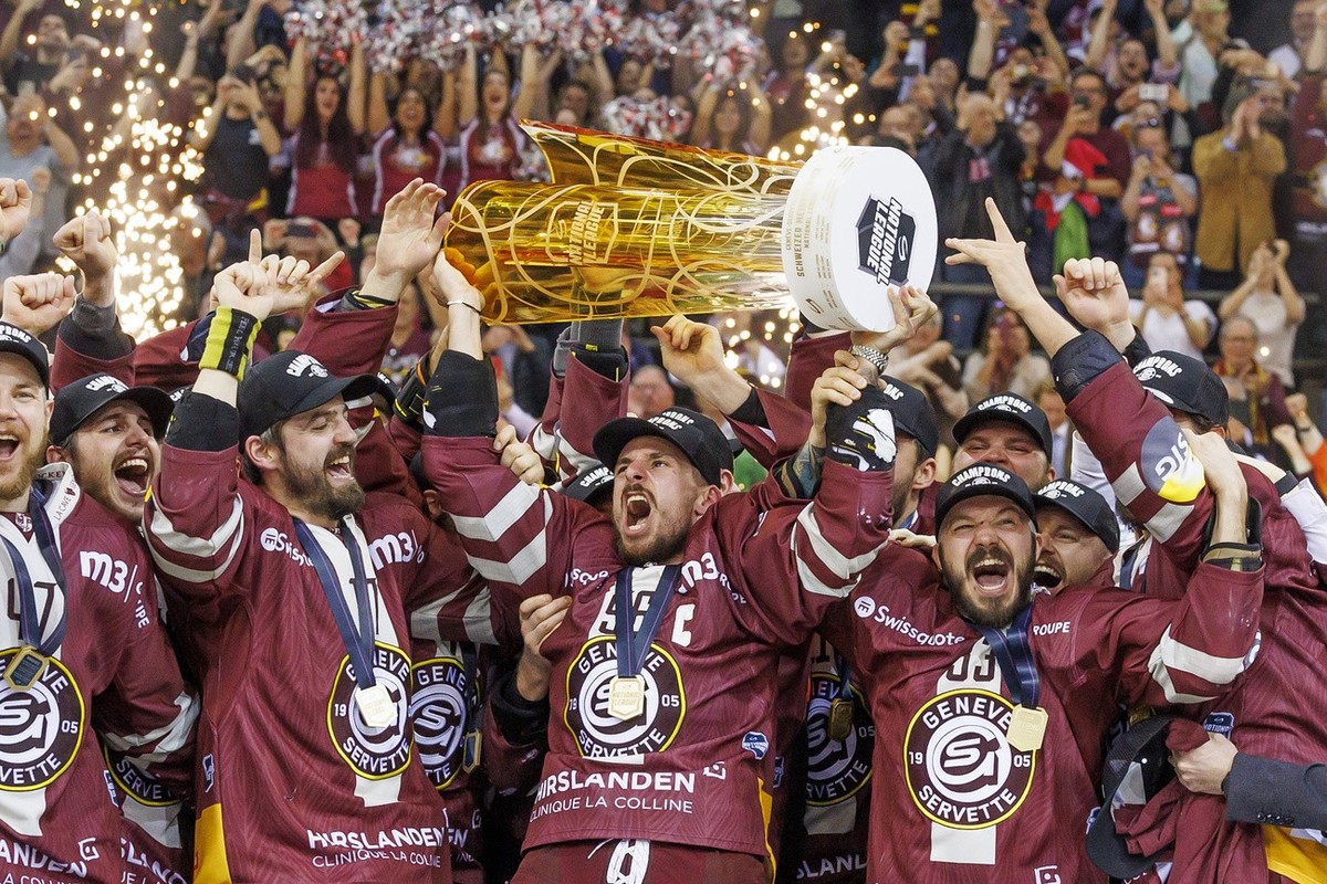 Geneve-Servette's forward Noah Rod lift the trophy after winning against Biel, during the seventh and final leg of the ice hockey National League Swiss Championship final playoff game between Gen ...