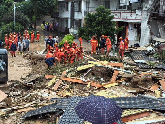 epa11502293 A handout photo made available by the Fire and Rescue Department of Hunan shows rescuers working at a landslide-hit area in Yuelin village of Shouyue Town in Hengyang City, central China,  ...