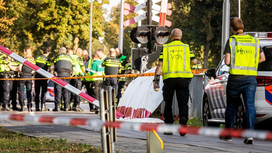 epa07034027 Members of the emergency services at the scene of a train crash with a cargo bike on a rail crossing in Oss, The Netherlands, 20 September 2018. Four children died, one child and an adult  ...