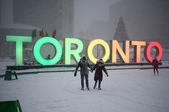 A couple skates during a snowstorm on an outdoor rink at city hall in Toronto, Ontario, Canada, December 15, 2016. REUTERS/Chris Helgren