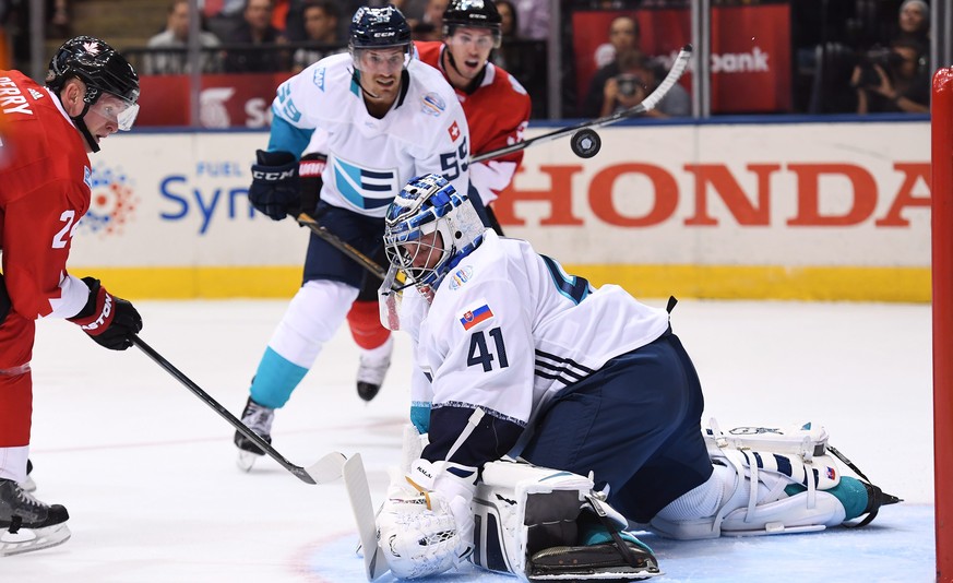 Team Europe goalie Jaroslav Halak makes a save on Team Canada&#039;s Corey Perry, left, as Europe&#039;s Roman Josi, center left, and Canada&#039;s Logan Couture look on during the first period of a W ...