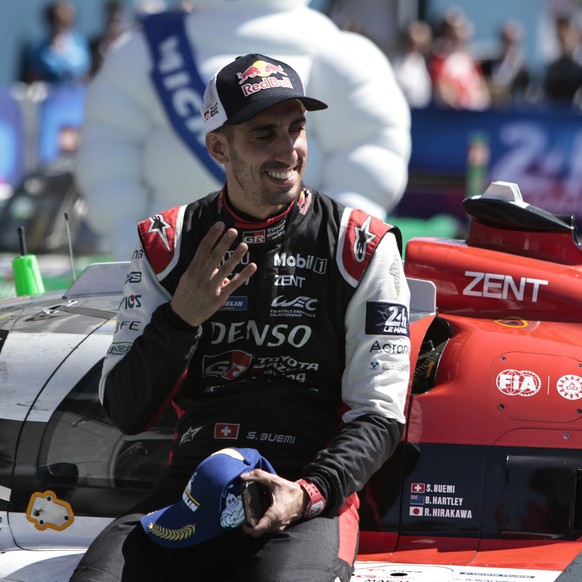 Sebastien Buemi of Switzerland, shows four fingers after winning the 24-Hour Le Mans endurance race with Brendon Hartley of New Zealand and Ryo Hirakawa of Japan in the Toyota Gazoo Racing GR010 Hybri ...