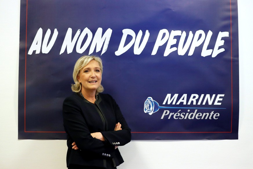 France&#039;s far-right National Front (FN) leader Marine Le Pen poses in front of a poster for her 2017 French presidential election campaign as she inaugurates her party campaign headquarters &quot; ...