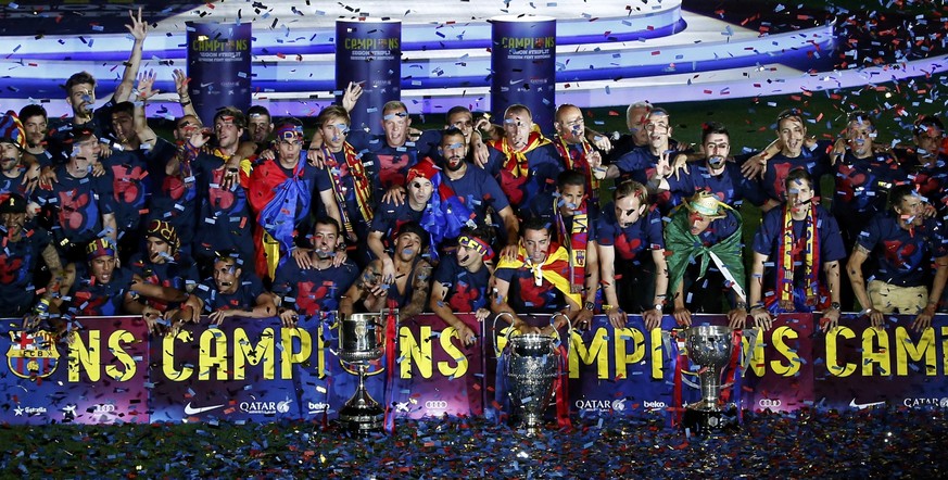 Barcelona&#039;s players and staff members pose with their trophies during celebration parade at Camp Nou stadium in Barcelona, Spain, June 7, 2015. Barcelona were crowned kings of Europe for the fift ...