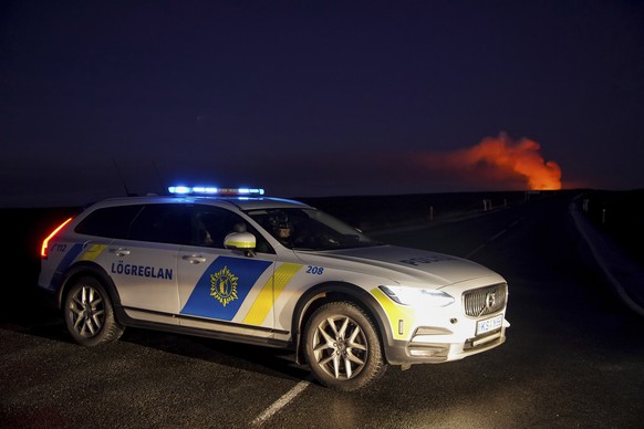 A police car blocks the access to the road that leads to Grindav�k, after a volcano erupted, seen from Su?urstrandavegur, Iceland, Sunday Jan. 14, 2024. A volcano has erupted in southwestern Iceland,  ...