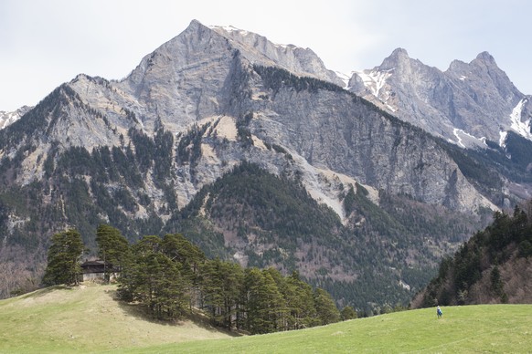 Eine Frau ist unterwegs zum Regitzer Spitz, mit Blick auf den Falknis, Schwarzhorn und Glegghorn, Hintergrund von links, am Donnerstag, 16. April 2015, auf dem Flaescherberg in Flaesch. (KEYSTONE/Gian ...