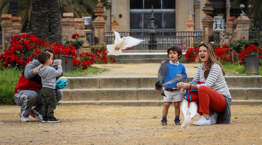 epa08385136 Adults and children gather at a park amid the ongoing coronavirus COVID-19 pandemic in Seville, Spain, 26 April 2020, on the first day that minors have been allowed for an hour a day outsi ...