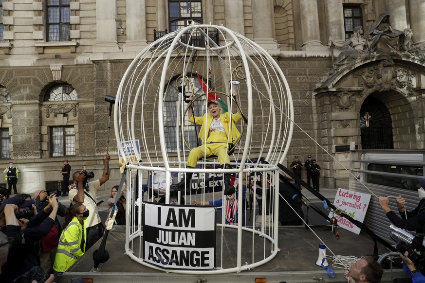 FILE - Fashion designer Vivienne Westwood sits suspended in a giant bird cage in protest against the extradition of WikiLeaks founder Julian Assange to the U.S., outside the Old Bailey court, in Londo ...