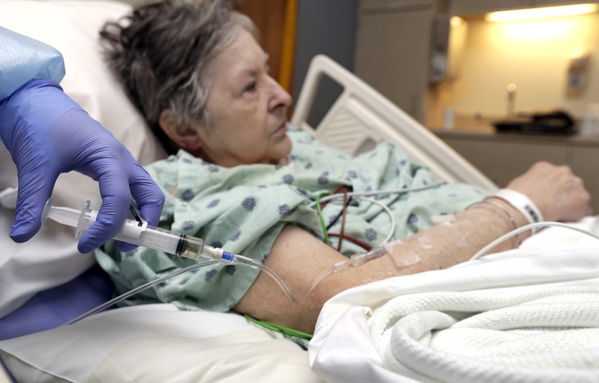 In this Monday, Jan. 8, 2018, photo, a nurse administers an I.V. push of antibiotics to Alice McDonald at ProMedica Toledo Hospital in Toledo, Ohio. A nasty flu season is hitting U.S. hospitals alread ...