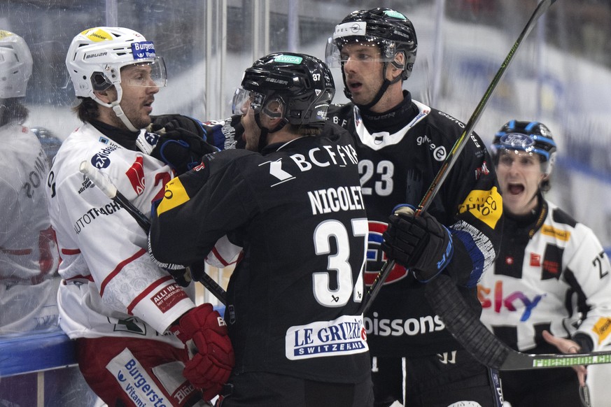 Kevin Nicolet (HCFG), Mitte, und Samuel Walser (HCFG), rechts, diskutieren mit Nico Duenner (SCRJ) im Spiel der Eishockey National League zwischen Fribourg-Gotteron, HCFG, und SC Rapperswil-Jona Laker ...