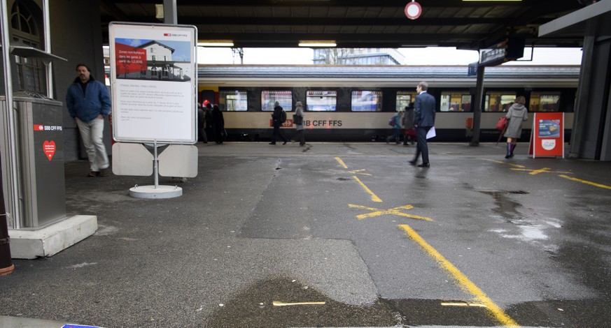 Un logo avec une cigarette barree (non-fumeur) photographie devant des personnes qui attendent le train CFF sur le quai ce jeudi 1 fevrier 2018 a la gare CFF de Nyon. Des le 1er fevrier, les CFF etend ...