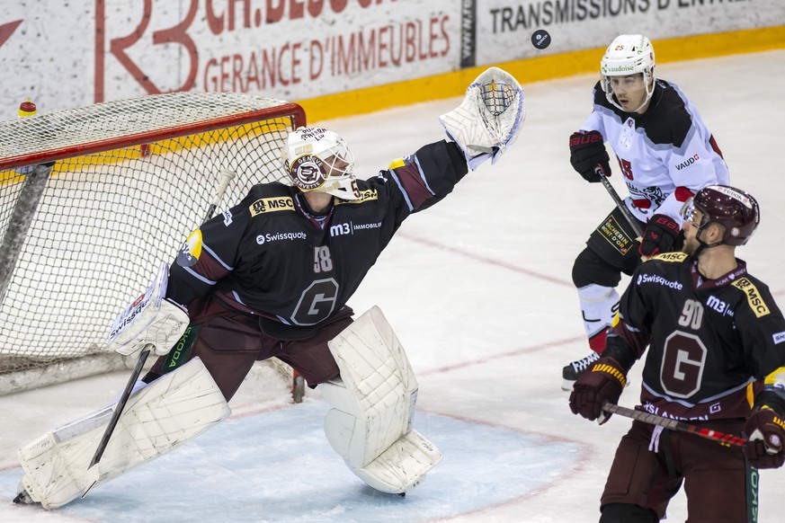 L&#039;attaquant lausannois Henrik Haapala, centre, a la lutte pour le puck avec le defenseur genevois Simon Le Coultre, droite, devant le gardien genevois Jussi Olkinuora, gauche, lors du match du ch ...