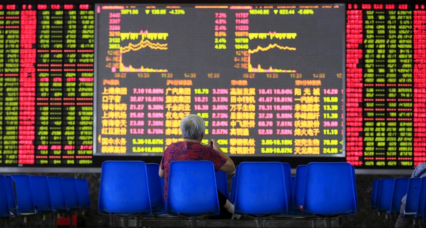 Eine Chinesin vor einem Screen der Shanghaier Börse.