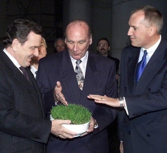 Swiss ambassador Thomas Borer, right, hands over to German Chancellor Gerhard Schroeder, left, a piece of lawn in the garden of the Chancellery Wednesday afternoon, December 12, 2001. The piece of law ...