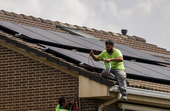 FILE - Workers install solar planers on the roof of a house in Rivas Vaciamadrid, Spain, Thursday, Sept. 15, 2022. Households and businesses across Europe have been suffering for months from soaring e ...