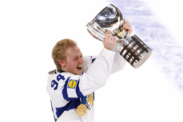 Finland's Konsta Helenius celebrates with the trophy after scoring the winning goal in extra time during the 2026 IIHF Men's Ice Hockey World Championship gold medal game between Switzerland ...