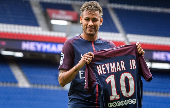 epa06124293 Brazilian striker Neymar Jr. poses for photographs with his new PSG jersey after a press conference at the Parc des Princes stadium in Paris, France, 04 August 2017. Neymar Jr is presented ...