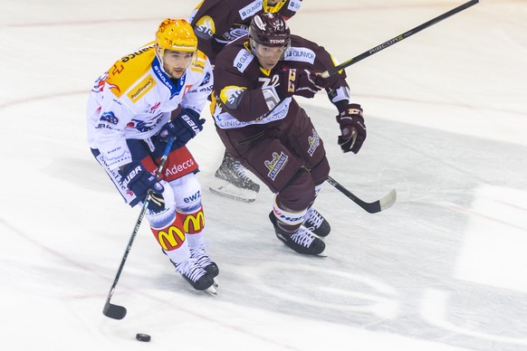 Le joueur zurichois, Maxim Noreau, gauche, a la lutte pour le puck avec le joueur genevois, Floran Douay, droite, lors du match du championnat suisse de hockey sur glace de National League LNA, entre  ...