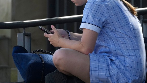 FILE - A young girl uses her phone while sitting on a bench in Sydney, Nov. 8, 2024. (AP Photo/Rick Rycroft, File)
Australia Social Media