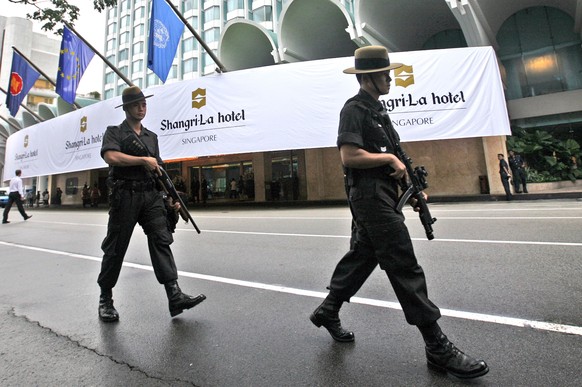 FILE - In this July 21, 2008, file photo, Singapore police officers patrol outside the Shangri-La hotel, a possible location for the upcoming Trump-Kim summit next month, in Singapore. Donald Trump an ...