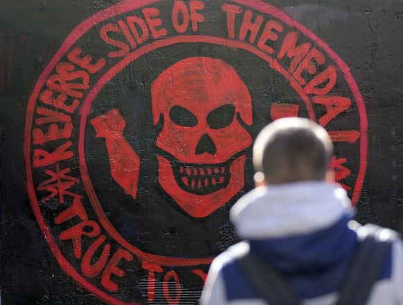 A boy walks past a repainted mural featuring the Russian Wagner Group logo on a wall in Belgrade, Serbia, Thursday, Jan. 19, 2023. (AP Photo/Darko Vojinovic)
