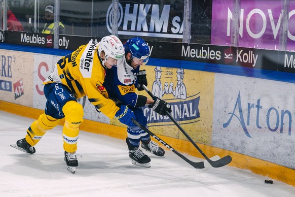 Calle Andersson (HCD), gauche, lutte pour le puck avec Christopher DiDomenico (HCFG), droite, lors du match du championnat suisse de hockey sur glace de National League entre le HC Fribourg Gotteron e ...