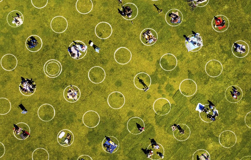 Circles designed to help prevent the spread of the coronavirus by encouraging social distancing line San Francisco's Dolores Park, Thursday, May 21, 2020. (AP Photo/Noah Berger)