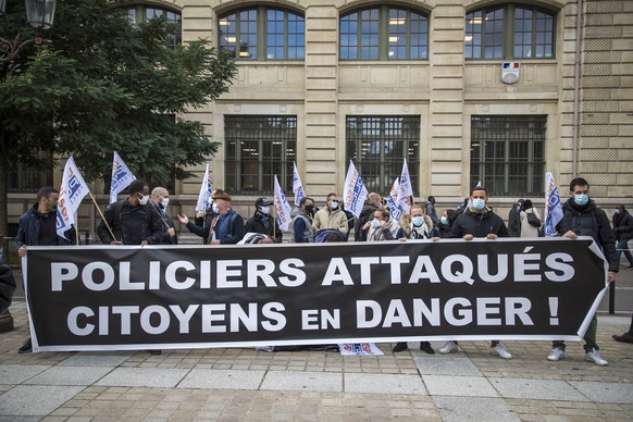 epa08737535 Members of French Police labor unions hold a banner reading &#039;Policemen attacked, citizens in danger!&#039; as they protest outside the Prefecture of Paris, France, 12 October 2020, fo ...