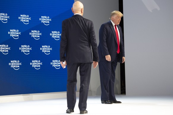 US President Donald Trump, right, and German Klaus Schwab, left, Founder and Executive Chairman of the World Economic Forum, WEF, arrives on stage before addressing a plenary session during to the 50th annual meeting of the World Economic Forum, WEF, in Davos, Switzerland, Tuesday, January 21, 2020. The meeting brings together entrepreneurs, scientists, corporate and political leaders in Davos from January 21 to 24. (KEYSTONE/Gian Ehrenzeller)