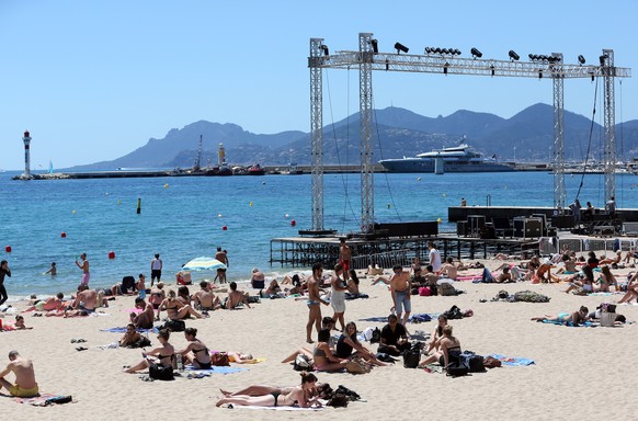 epa08402945 (20/20) (FILE) People enjoy the sun and the sea on the beach next to the giant screen of the Cinema de la Plage, the Festival&#039;s outdoors theatre, ahead of the 66th annual Cannes Film  ...