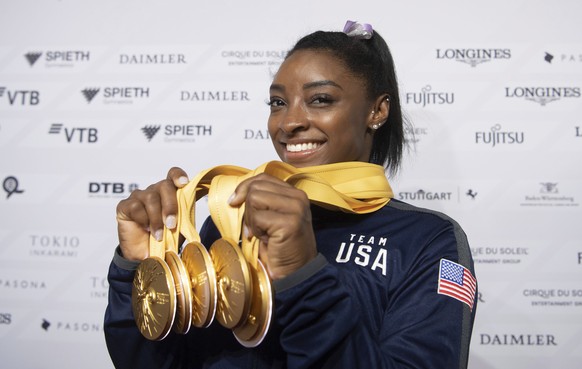 Simone Biles of the United States shows her five gold medals at the Gymnastics World Championships in Stuttgart, Germany, Sunday, Oct. 13, 2019. (Marijan Murat/dpa via AP)